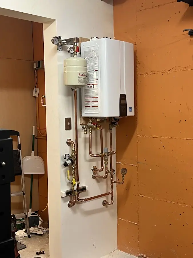 Plumbing technician inspecting water heater connections in Cache